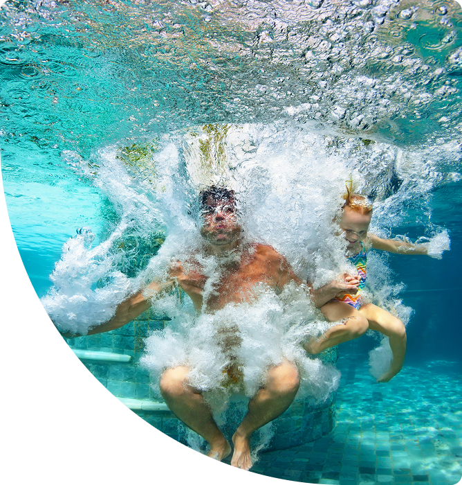 Two people jumping into a clear, swimming pool referencing have fun in clean, safe pool